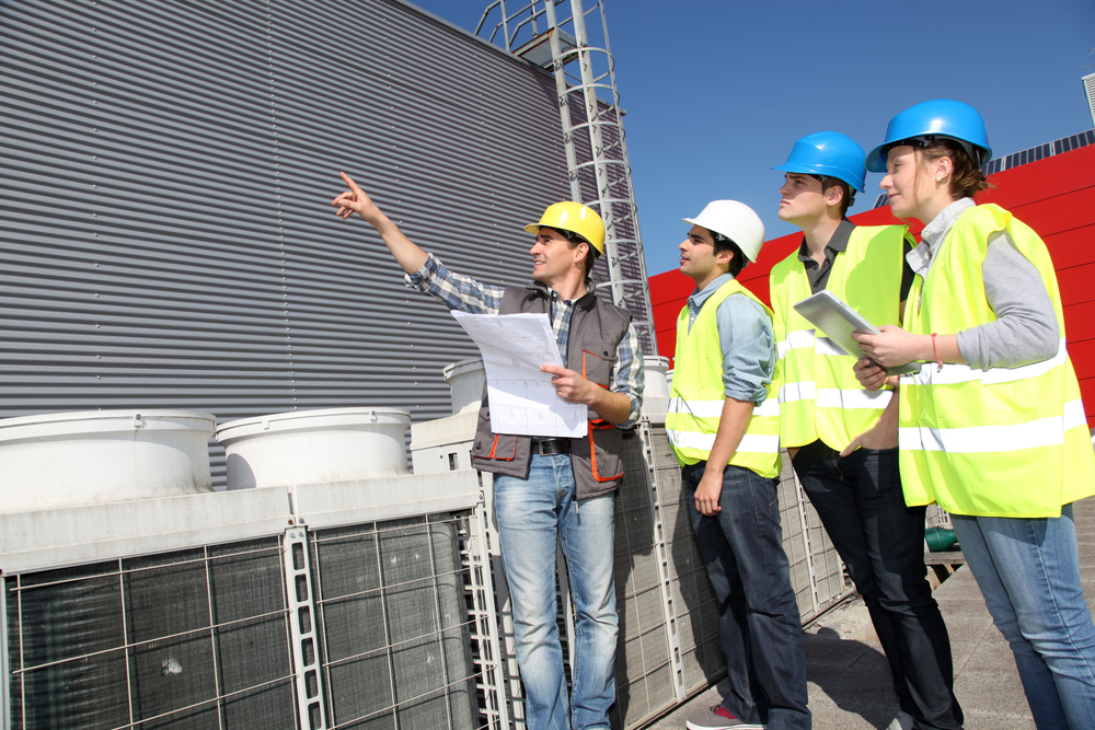 Group of workers inspecting cooling tower.